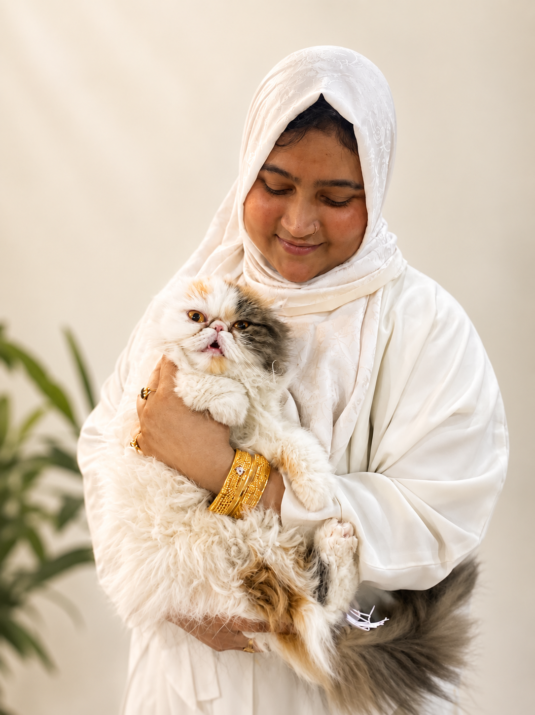 Managing Director of Pace Agrovet holding a Persian cat and smiling in a professional portrait.